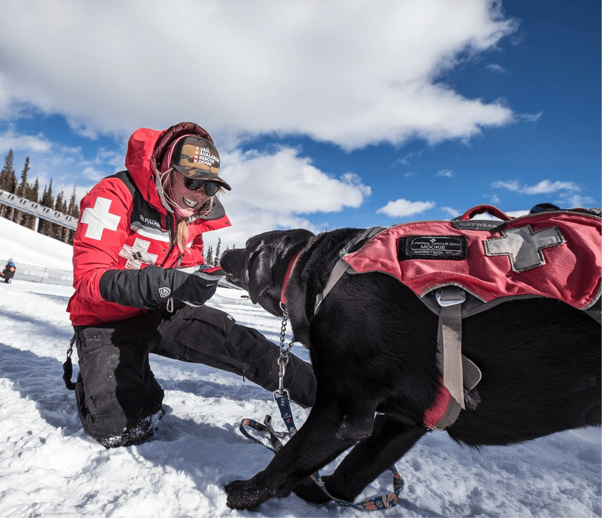 Ski patrol with rescue dog in snow